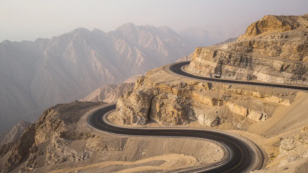 Winding mountain road ascending Jebel Jais with dramatic rocky peaks and hairpin curves