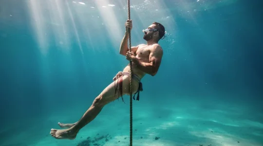 Traditional pearl diver descending in the warm waters of the Arabian Gulf